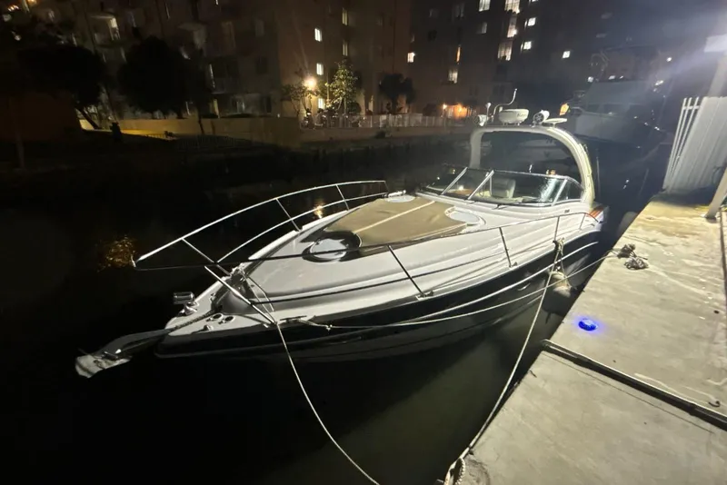 Slide: The Image of 2007 Four Winns V338 boat docked at night, illuminated by nearby lights. - 2