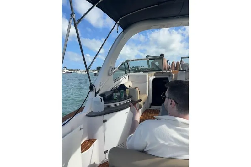 Slide: The Image of 2007 Four Winns V338 boat interior with person relaxing, scenic water view. - 4