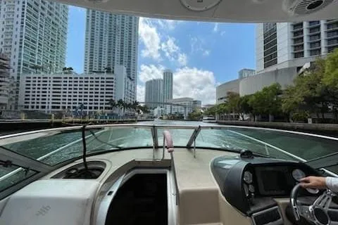 Slide: The Image of 2007 Four Winns V338 boat navigating through a city waterway with skyscrapers. - 6