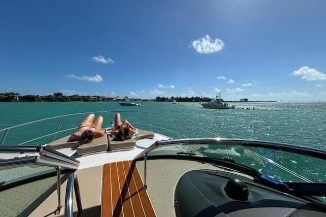 Slide: The Image of Two people sunbathing on a 2007 Four Winns V338 yacht, enjoying a sunny day at sea. - 9
