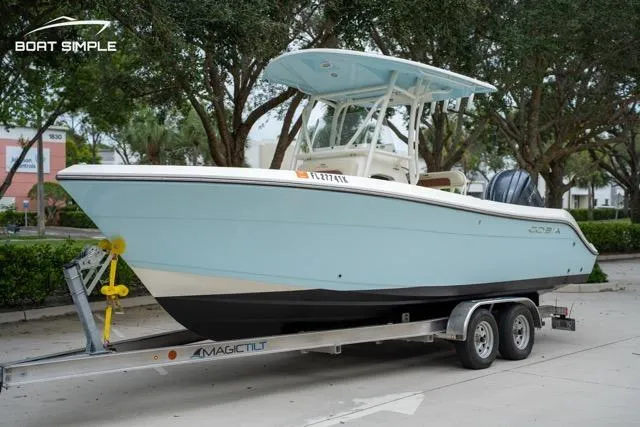 Slide: The Image of 2023 Cobia 240 Center Console boat on trailer, parked outdoors. - 1