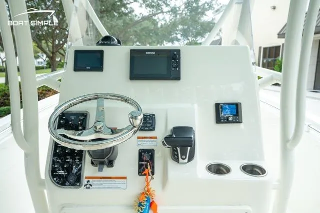 Slide: The Image of 2023 Cobia 240 Center Console boat dashboard with steering wheel and navigation equipment. - 15