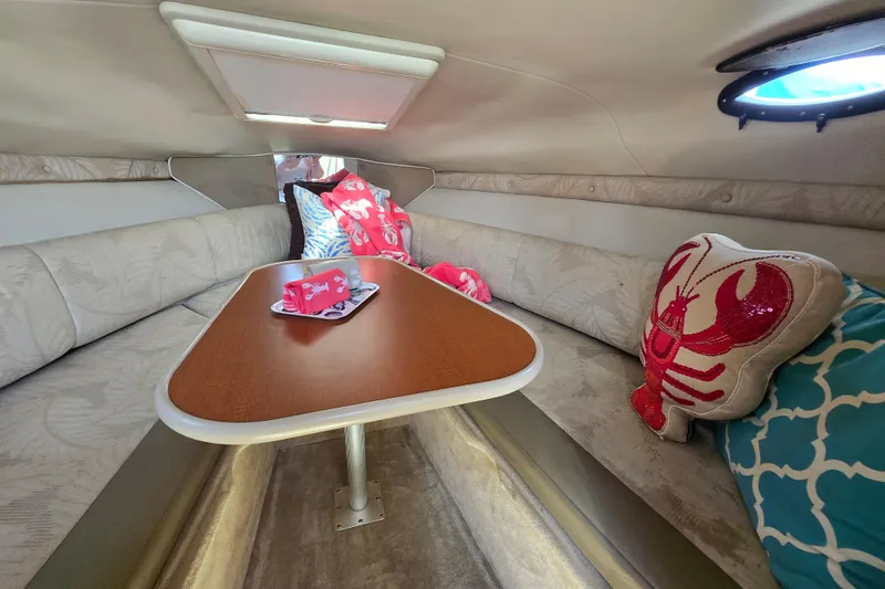 Slide: The Image of Interior of 2004 Chaparral Signature 240 boat with cozy seating and decorative pillows. - 12