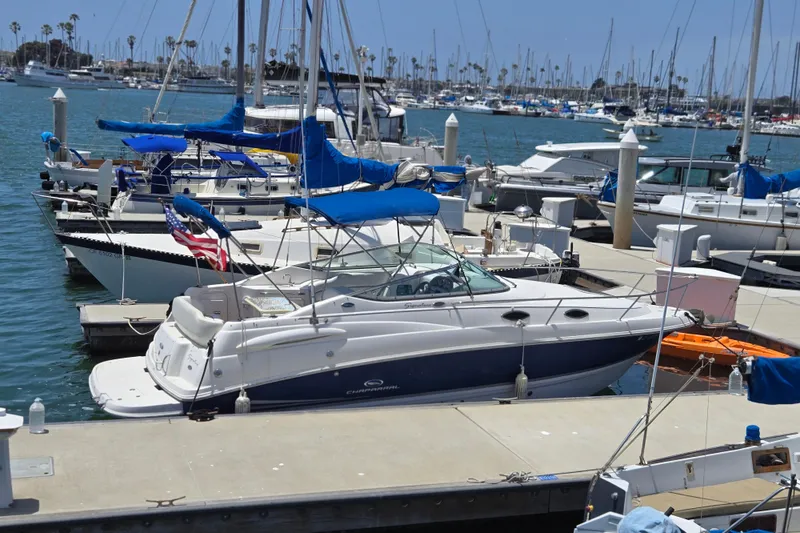 Slide: The Image of 2004 Chaparral Signature 240 boat docked at a marina with other vessels. - 15