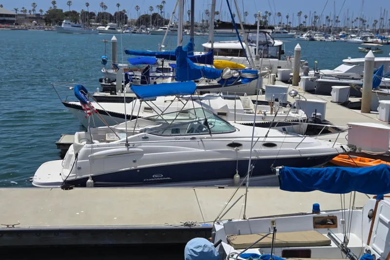 Slide: The Image of 2004 Chaparral Signature 240 boat docked in a marina with other vessels. - 16