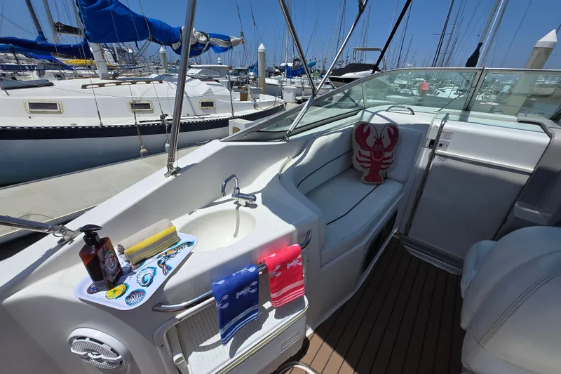 Slide: The Image of 2004 Chaparral Signature 240 boat interior with seating, nautical decor, and docked sailboats. - 8