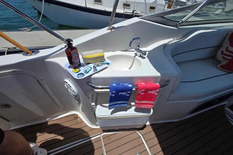 Slide: The Image of 2004 Chaparral Signature 240 boat interior with sink, towels, and seating area. - 9