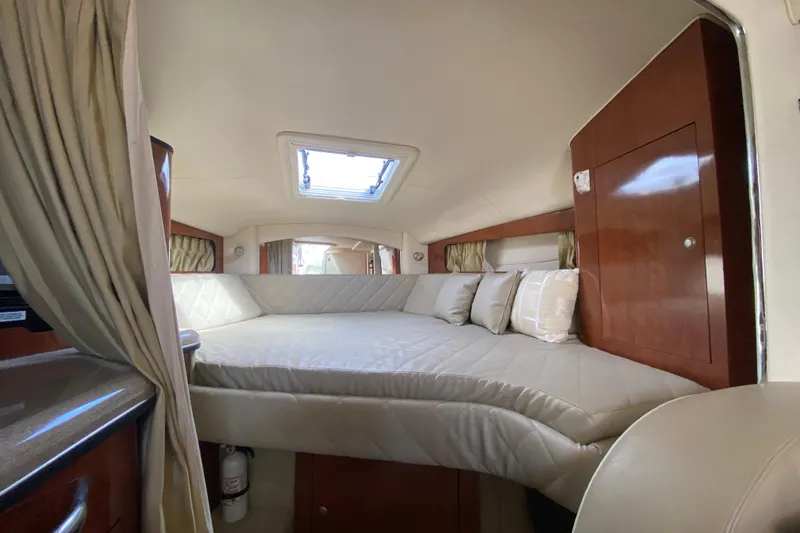Slide: The Image of Interior cabin of 2007 Sea Ray 300 Sundancer with cozy bed and wooden cabinetry. - 18