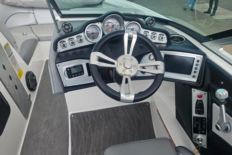 Slide: The Image of 2016 MasterCraft X23 boat dashboard with steering wheel and control panel. - 15