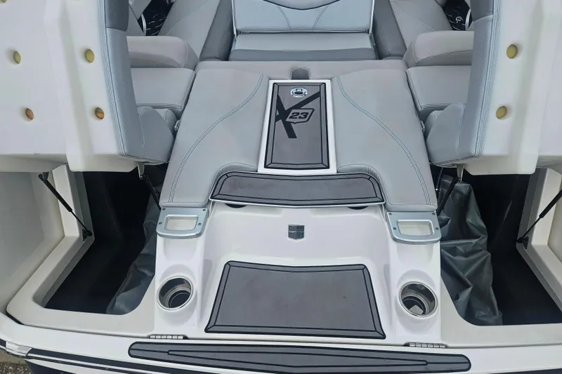 Slide: The Image of 2016 MasterCraft X23 boat interior with gray seating and storage compartments. - 18