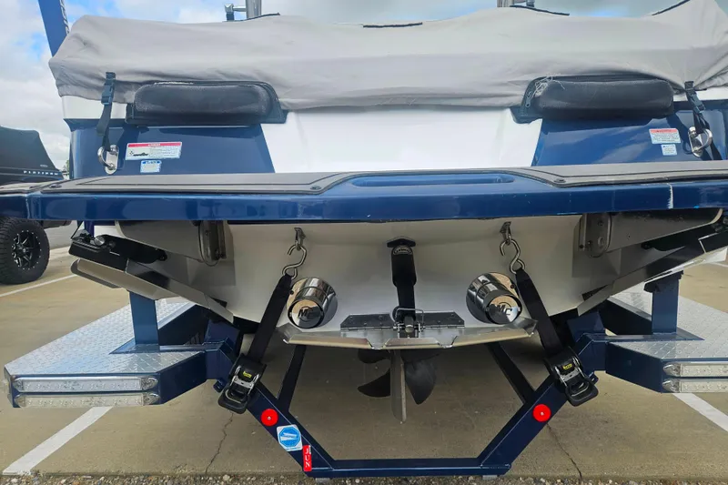 Slide: The Image of 2016 MasterCraft X23 boat rear view, showcasing propeller and trim tabs. - 8