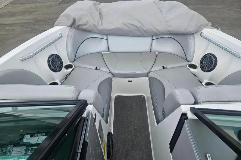 Slide: The Image of 2016 MasterCraft X23 boat interior with gray seating and built-in speakers. - 9