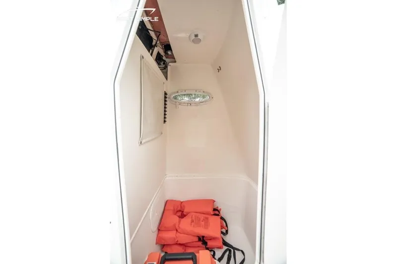 Slide: The Image of 2023 Cobia 240 Center Console interior with life jackets and storage space. - 25