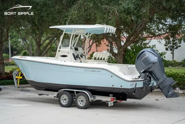 Slide: The Image of 2023 Cobia 240 Center Console boat on trailer, parked outdoors. - 2