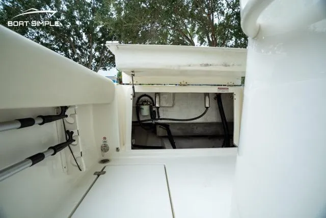 Slide: The Image of 2023 Cobia 240 Center Console boat storage compartment with open hatch, showcasing interior details. - 24