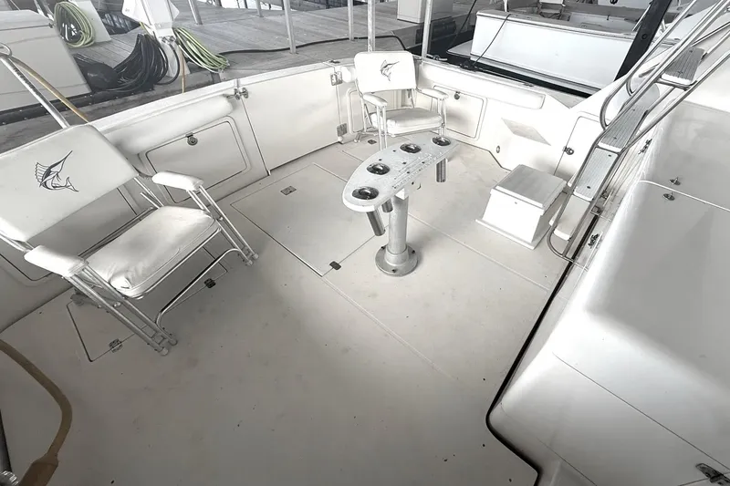 Slide: The Image of 1996 Riviera 39 Open Flybridge boat deck with chairs and fishing rod holders. - 14