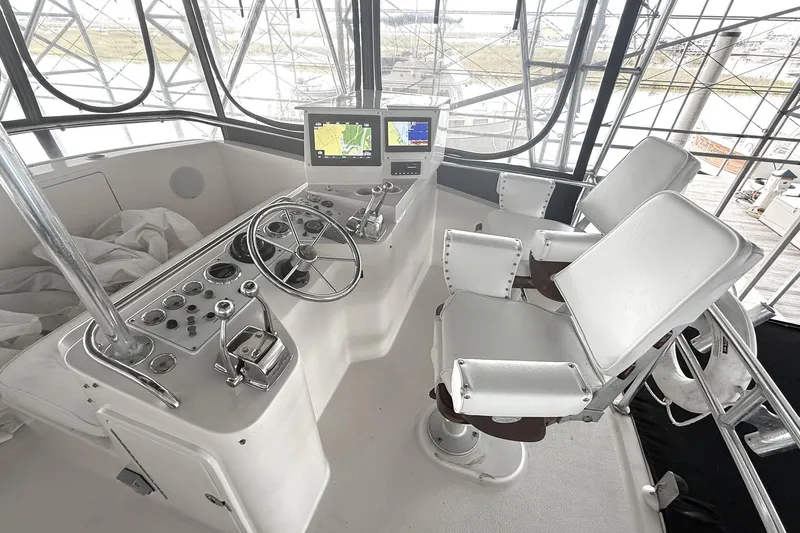 Slide: The Image of 1996 Riviera 39 Open Flybridge helm with dual seats, steering wheel, and navigation screens. - 4