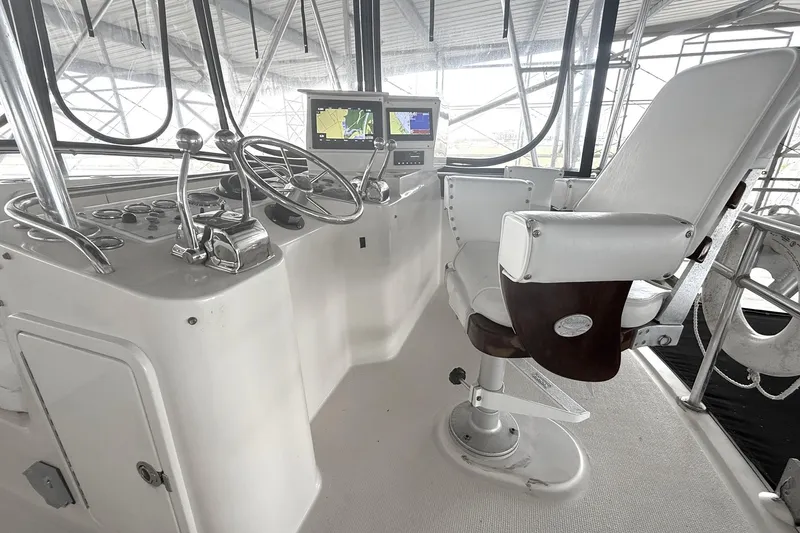 Slide: The Image of 1996 Riviera 39 Open Flybridge helm with steering wheel, controls, and navigation display. - 5