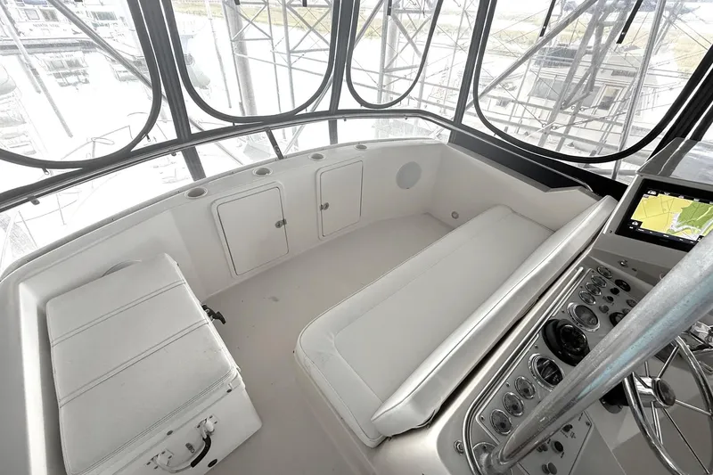 Slide: The Image of 1996 Riviera 39 Open Flybridge interior with white seating and navigation controls. - 6