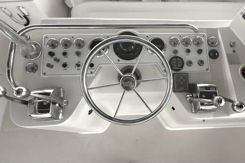 Slide: The Image of Control panel of a 1996 Riviera 39 Open Flybridge boat with steering wheel and gauges. - 9