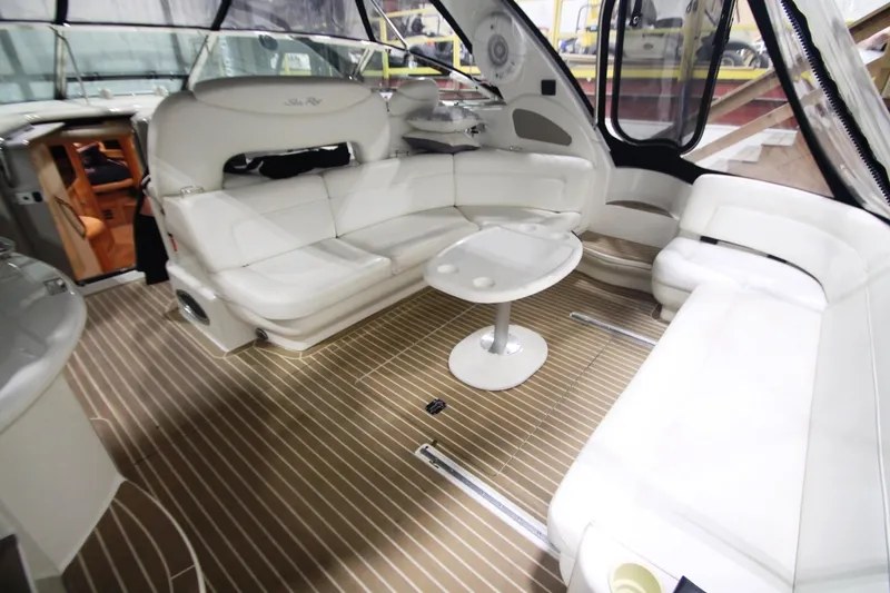 Slide: The Image of 1999 Sea Ray 460 Sundancer interior with white seating and wooden flooring. - 16