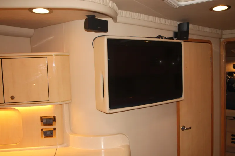 Slide: The Image of Interior of 1999 Sea Ray 460 Sundancer with mounted TV and wooden cabinetry. - 31