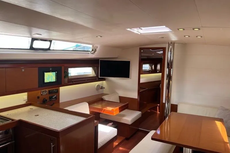 Slide: The Image of Interior of 2013 Beneteau Oceanis 45 yacht, featuring modern dining and navigation area. - 19