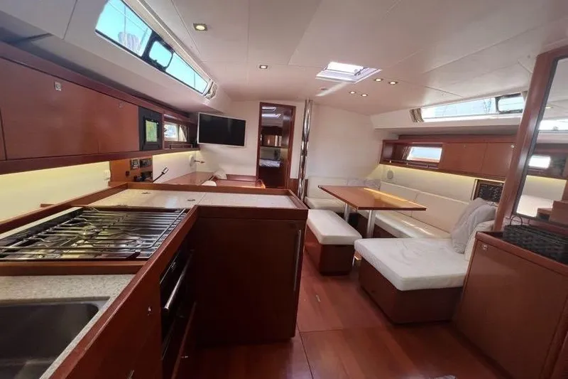 Slide: The Image of Interior of 2013 Beneteau Oceanis 45 yacht, featuring modern kitchen and dining area. - 21