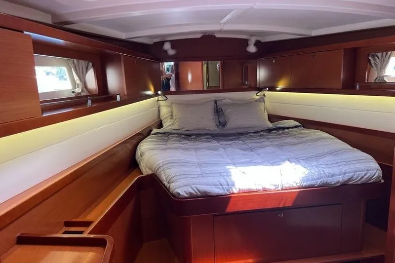 Slide: The Image of Luxurious cabin interior of 2013 Beneteau Oceanis 45 yacht with cozy bed and wooden finish. - 24