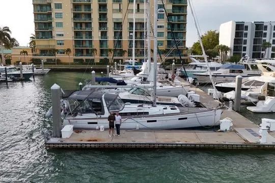 Slide: The Image of 2013 Beneteau Oceanis 45 docked at marina with waterfront buildings in background. - 31