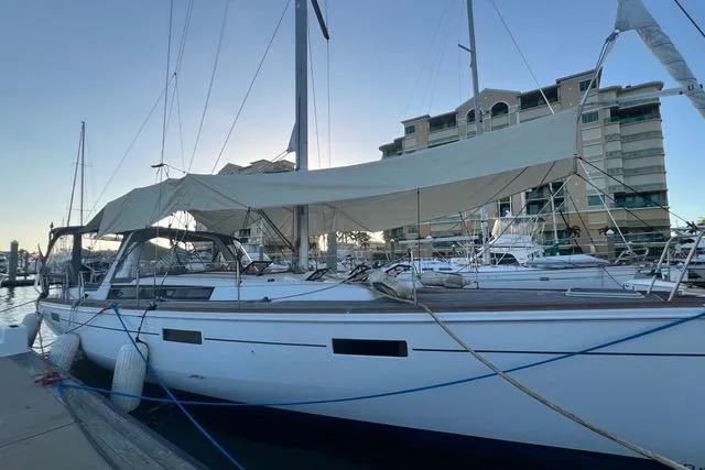 Slide: The Image of 2013 Beneteau Oceanis 45 sailboat docked at marina, with modern buildings in background. - 6