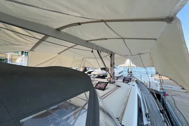 Slide: The Image of 2013 Beneteau Oceanis 45 sailboat with canopy, docked by the sea. - 8
