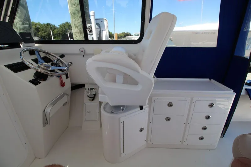 Slide: The Image of Interior of 2019 Judge 27 Chesapeake boat with steering wheel and white seating. - 16