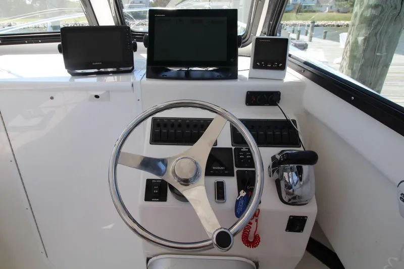 Slide: The Image of 2019 Judge 27 Chesapeake boat helm with steering wheel and navigation equipment. - 17