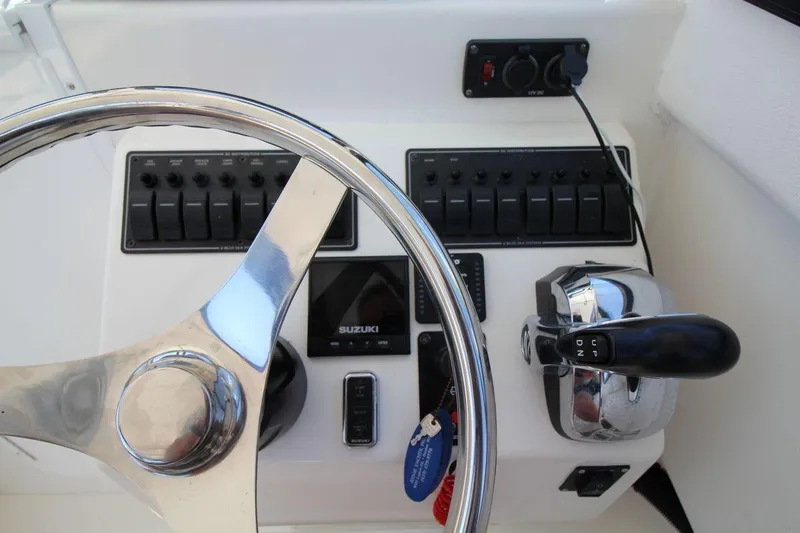 Slide: The Image of Steering console of 2019 Judge 27 Chesapeake boat with Suzuki controls and switches. - 19