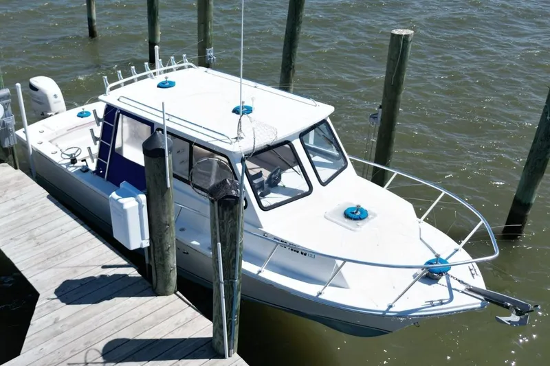 Slide: The Image of 2019 Judge 27 Chesapeake boat docked on calm water. - 2