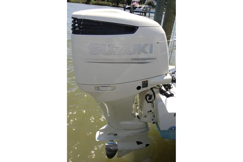 Slide: The Image of Suzuki outboard motor on 2019 Judge 27 Chesapeake boat, docked in water. - 23