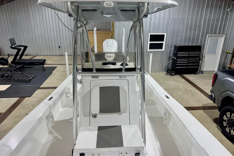 Slide: The Image of 2023 BlackJack 256 Coastal boat in a garage with exercise equipment and tools. - 13