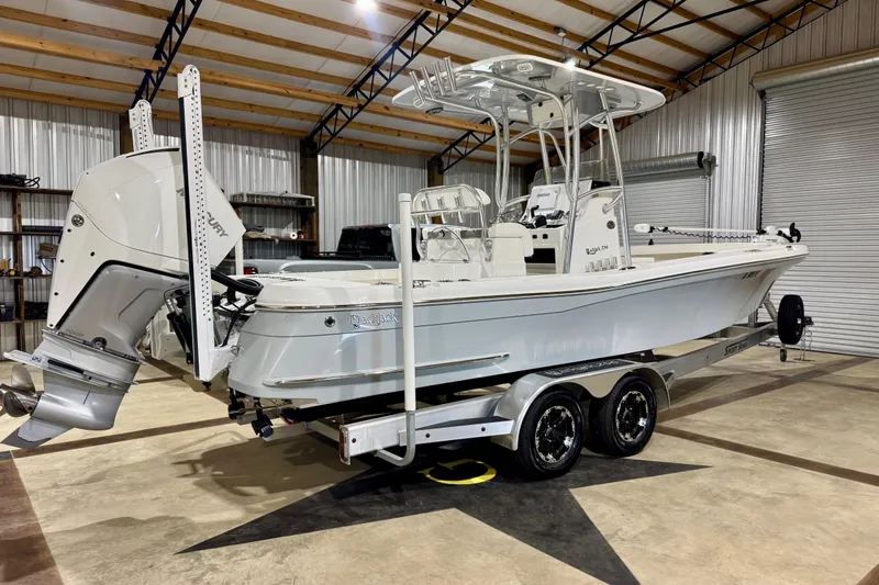 Slide: The Image of 2023 BlackJack 256 Coastal boat in a garage, on a dual-axle trailer. - 3