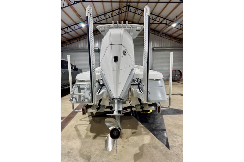 Slide: The Image of 2023 BlackJack 256 Coastal boat in a garage, rear view showing motor and propeller. - 4