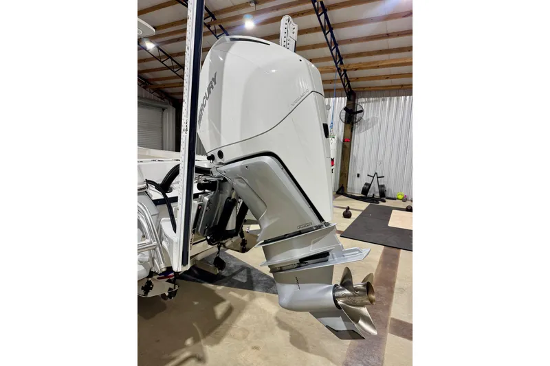 Slide: The Image of 2023 BlackJack 256 Coastal boat with Mercury outboard motor in a garage setting. - 5