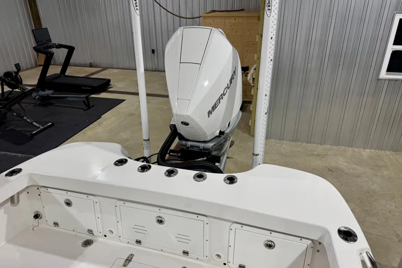 Slide: The Image of 2023 BlackJack 256 Coastal boat with Mercury engine in a garage setting. - 6
