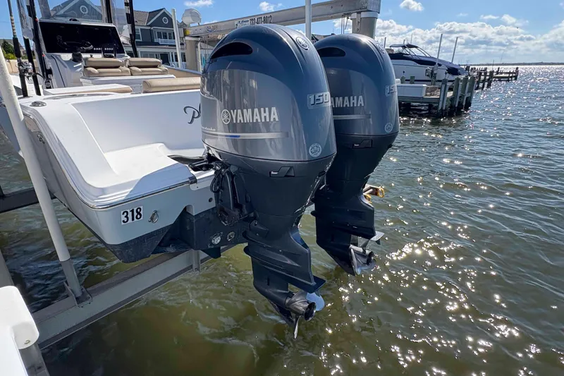 Slide: The Image of 2018 Sportsman Open 252 Center Console with twin Yamaha 150 engines docked by the water. - 11