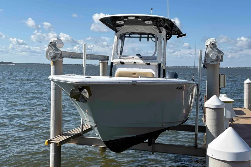 Slide: The Image of 2018 Sportsman Open 252 Center Console boat on lift by the water. - 3