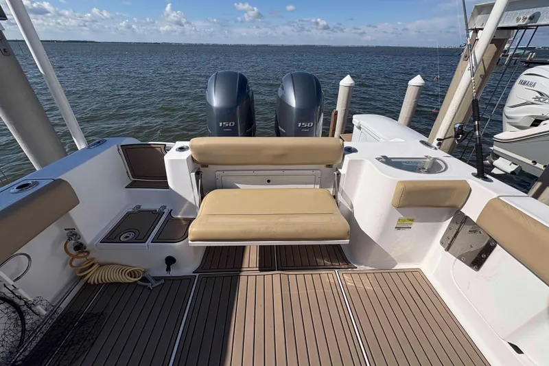 Slide: The Image of 2018 Sportsman Open 252 Center Console boat with dual engines, docked by the water. - 6