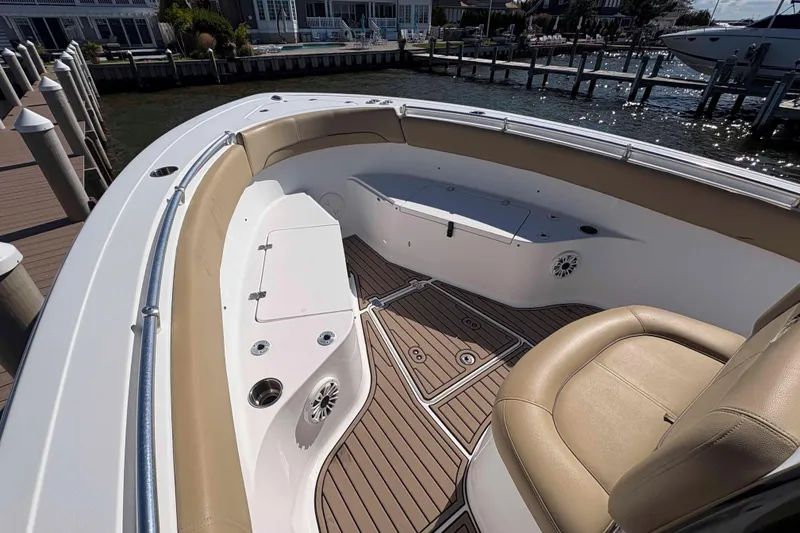 Slide: The Image of 2018 Sportsman Open 252 Center Console boat interior with tan seating and wood-style flooring. - 9