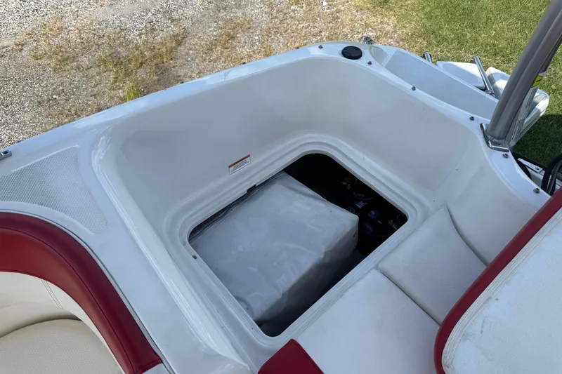 Slide: The Image of 2013 Bayliner Element boat storage compartment with red and white seating. - 11