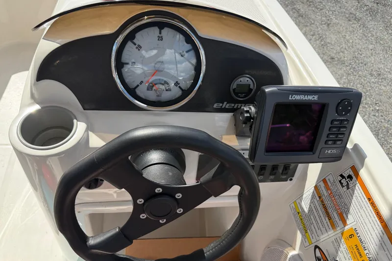 Slide: The Image of 2013 Bayliner Element dashboard with steering wheel, gauges, and Lowrance HDS-5 display. - 13