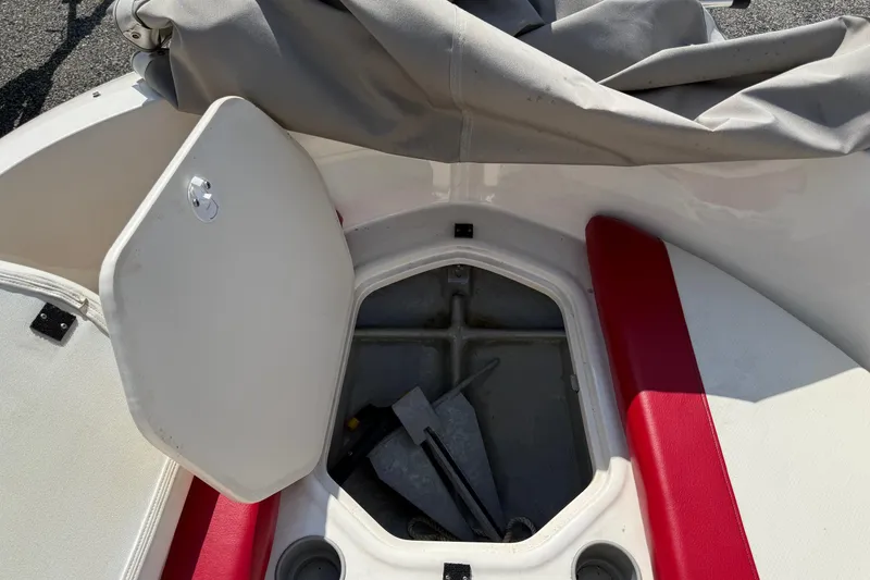 Slide: The Image of Open storage compartment on 2013 Bayliner Element boat with red and white seating. - 16