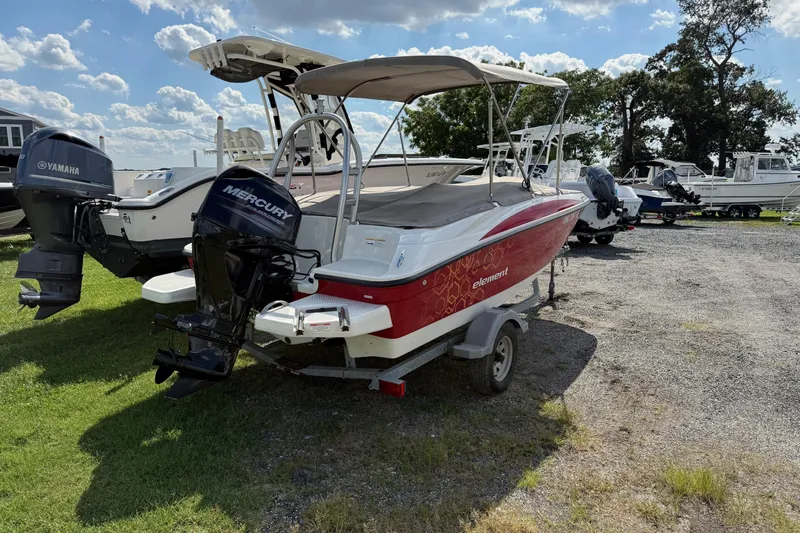 Slide: The Image of 2013 Bayliner Element boat with Mercury outboard motor on a trailer, parked outdoors. - 5